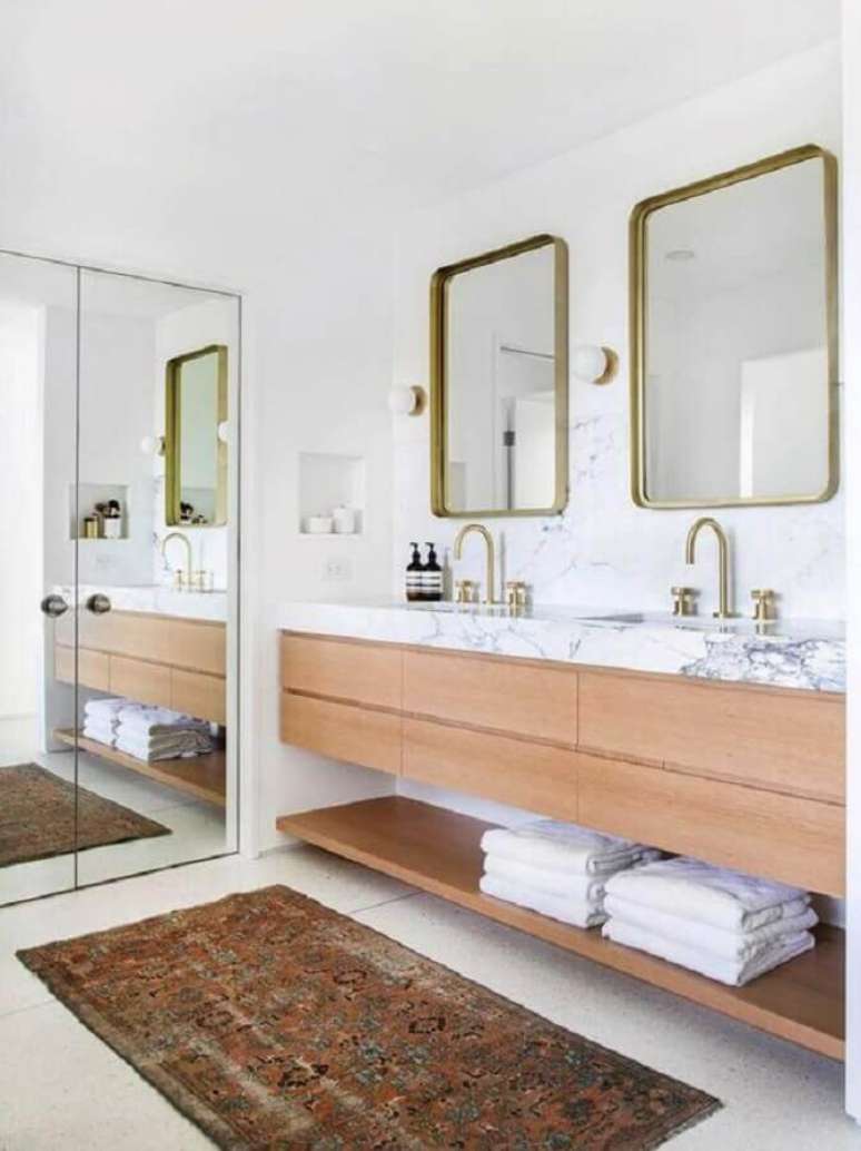 31. Banheiro sob medida amplo decorado com espelho com moldura dourada e gabinete de madeira – Foto: Emily Henderson Design