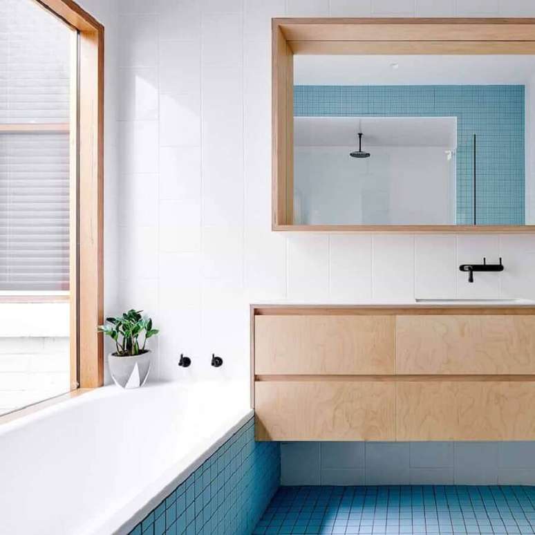 33. Banheiro sob medida azul e branco decorado com móveis de madeira – Foto: Apartment Therapy