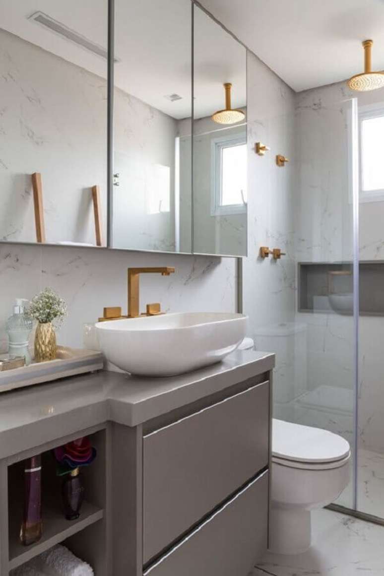 42. Decoração em tons de cinza para banheiro sob medida com detalhes em dourado – Foto: Jeito de Casa