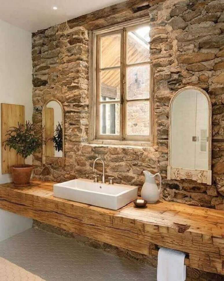 11. Decoração rústica para banheiro sob medida com bancada de madeira e revestimento de pedra para parede – Foto: Architecture Art Designs
