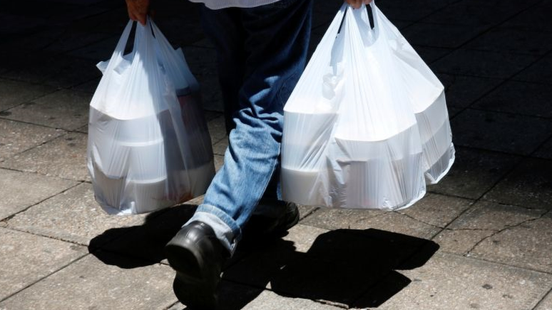 Homem buscando comida em meio à pandemia; delivery, comércio eletrônico e materiais hospitalares descartáveis fizeram uso de plástico explodir