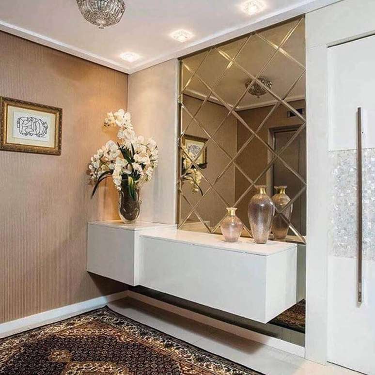 12. Decora&ccedil;&atilde;o sofisticada para hall de entrada com espelho planejado e aparador suspenso &ndash; Foto: Pinterest