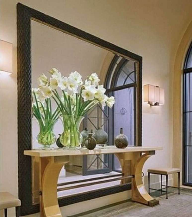 19. Decora&ccedil;&atilde;o sofisticada para hall de entrada com espelho grande e aparador bege com vasos de flores &ndash; Foto: Pinterest