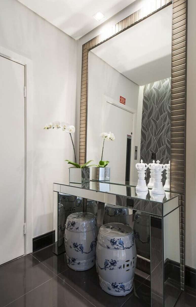 24. Decora&ccedil;&atilde;o de hall de entrada com espelho grande e aparador espelhado com seat garden embaixo &ndash; Foto: Pinterest