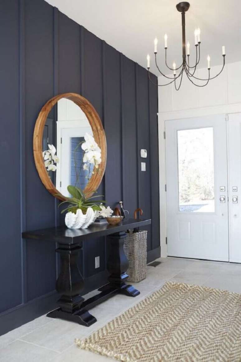 27. Decora&ccedil;&atilde;o de hall de entrada azul e branco com espelho redondo e aparador de preto &ndash; Foto: Jeito de Casa
