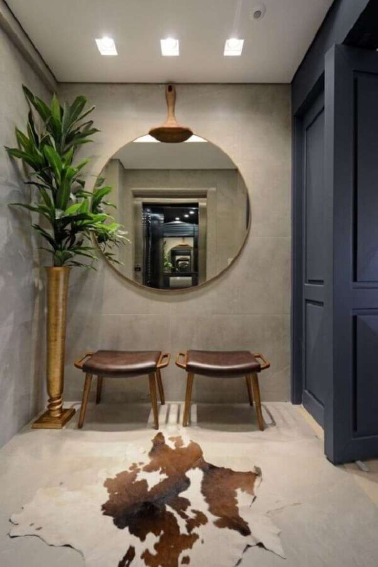 40. Decora&ccedil;&atilde;o moderna para hall de entrada com espelho redondo e tapete de couro &ndash; Foto: Home Fashion Trend