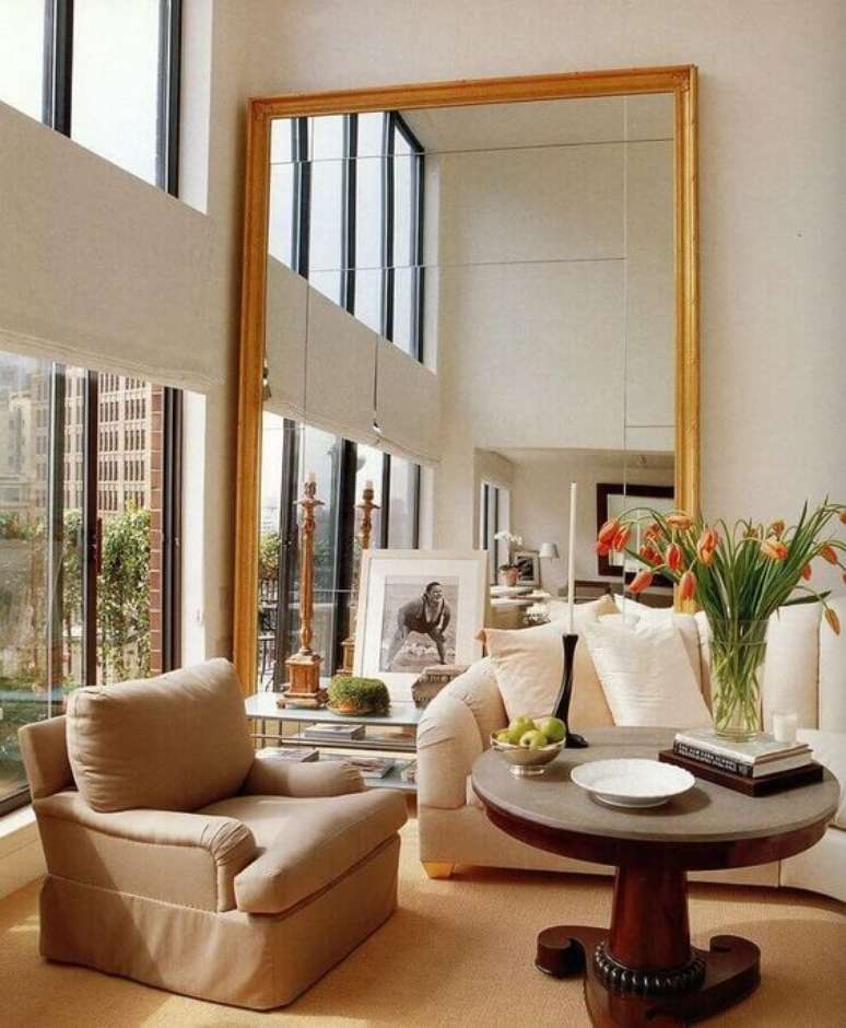 27. Espelho dourado grande na sala de estar – Via: Revista VD