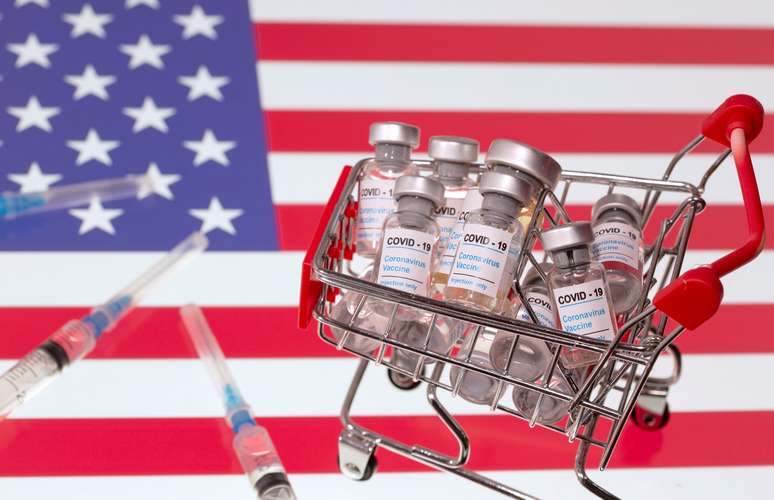 Pequeno carrinho de compras cheio de frascos etiquetados "COVID-19 - Vacina contra o Coronavírus" e seringas médicas são colocadas à frente da bandeira dos EUA nesta ilustração feita em 29 de novembro de 2020. REUTERS/Dado Ruvic