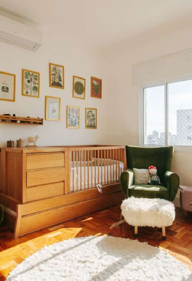 1. Berço com gaveta de madeira se contrasta com a poltrona verde. Fonte: Histórias de Casa