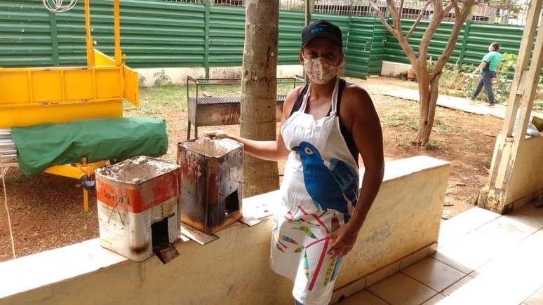 Anely cozinha marmitas para fora em seu fogareiro de carvão