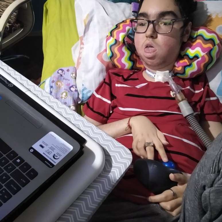 "Santiago gosta muito do computador, ele é muito inteligente." O adolescente usa um trackball, um mouse com uma bola, para escrever no computador e aprendeu inglês "no Google e no YouTube"