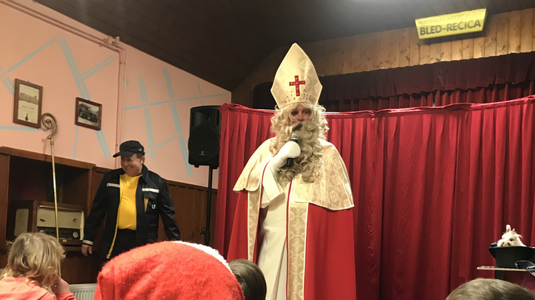 Em evento em 2019, homem caracterizado de São Nicolau entrega presentes para crianças em festa tradicional em Bled, na Eslovênia