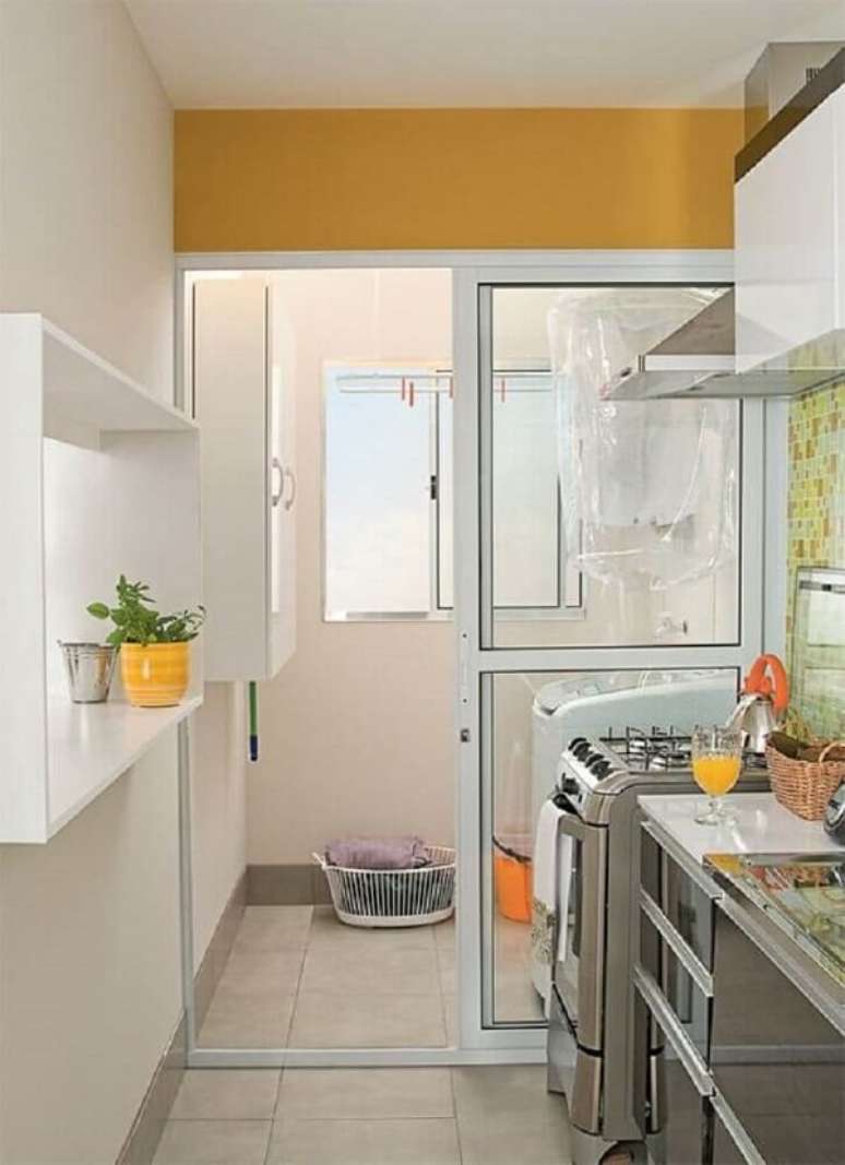 61. Aqui a porta de vidro separa a área de serviço da cozinha. Fonte: Falk Art e Decoração