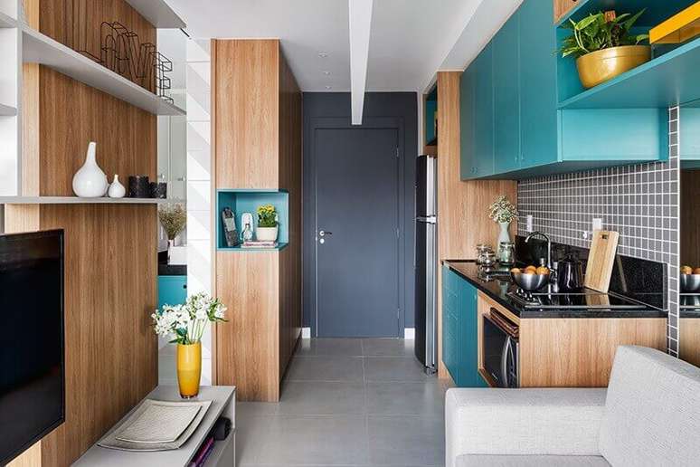 44. Móveis planejados em madeira e azul turquesa para decoração de sala e cozinha integrada pequena – Foto: Pinterest