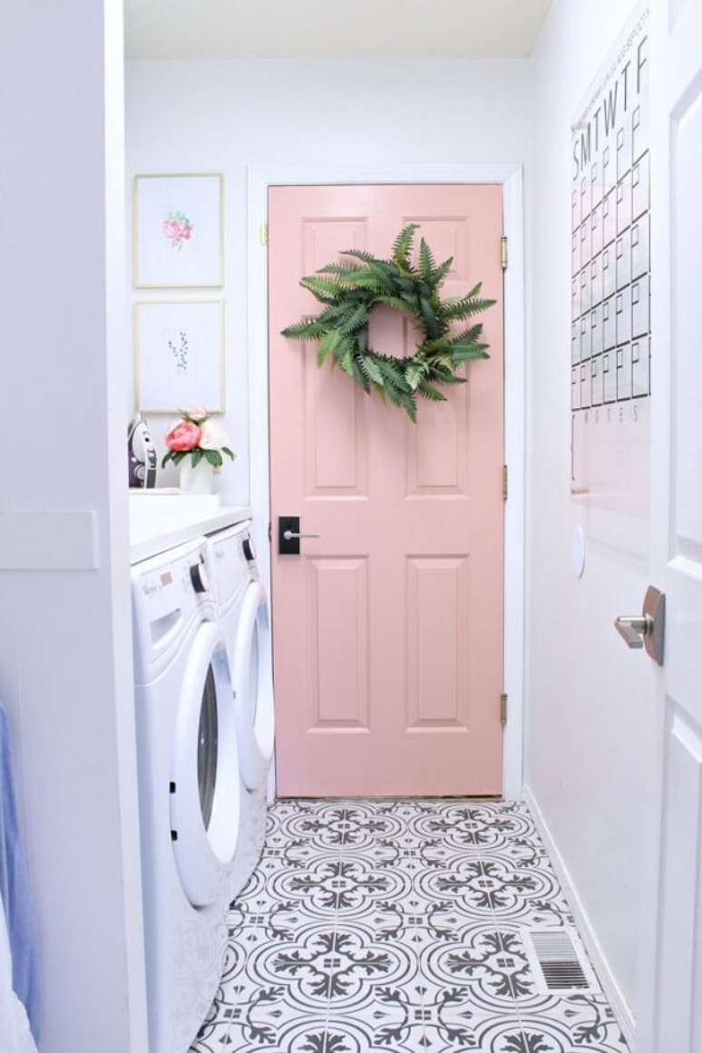 26. Os quadros delicados e a porta rosa deixaram a área de serviço simples charmosa. Fonte: Pinterest