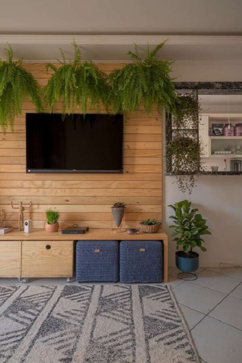 25. Decoração de sala de TV com painel de madeira e vasos de plantas pendentes – Foto: Pinterest