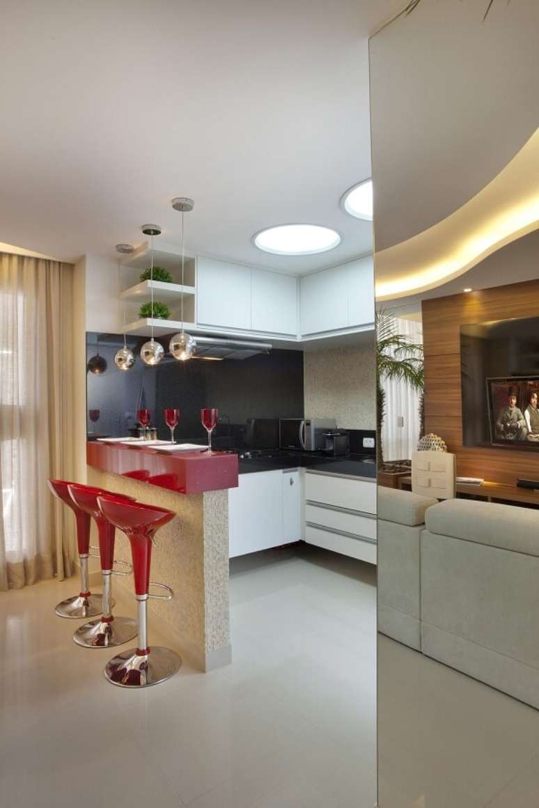 38. A banqueta vermelha auxilia no melhor aproveitamento dos espa&ccedil;os. Projeto por Iara Kilaris