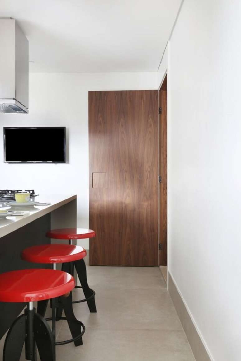 34. A banqueta vermelha met&aacute;lica &eacute; a grande protagonista do ambiente. Projeto por SP Estudio