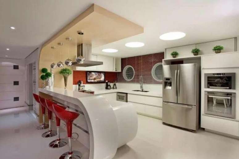 21. Ambiente moderno e clean com banqueta vermelha alta. Projeto por Iara K&iacute;laris