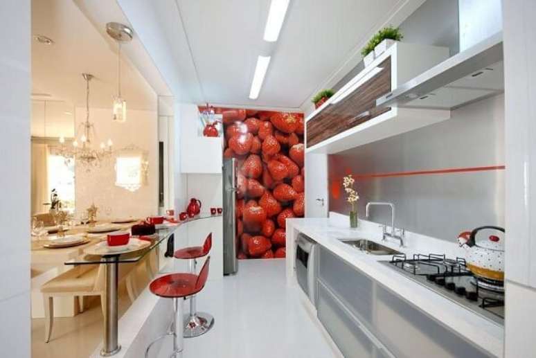 3. As banquetas para balcão vermelha se conectam diretamente com o painel de morangos. Projeto por Renato Feroldi