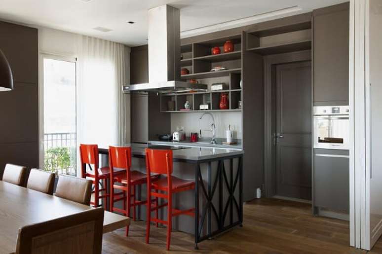 6. As banquetas para balcão vermelha se destacam nessa cozinha moderna. Projeto por Ornare