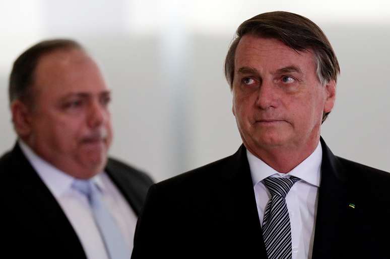 Bolsonaro, com Pazuello ao fundo no Pal&aacute;cio do Planalto
 8/12/2020 REUTERS/Ueslei Marcelino