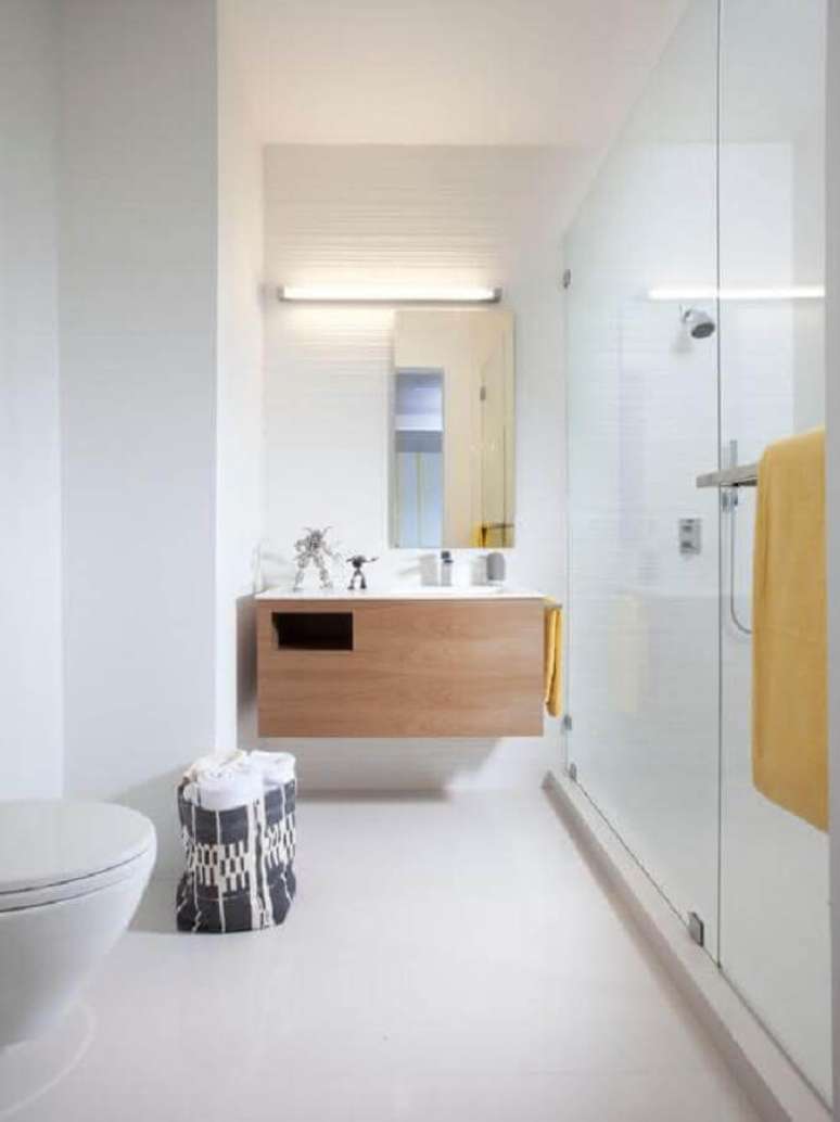 13. Banheiro minimalista branco decorado com gabinete de madeira planejado – Foto: Casa de Valentina