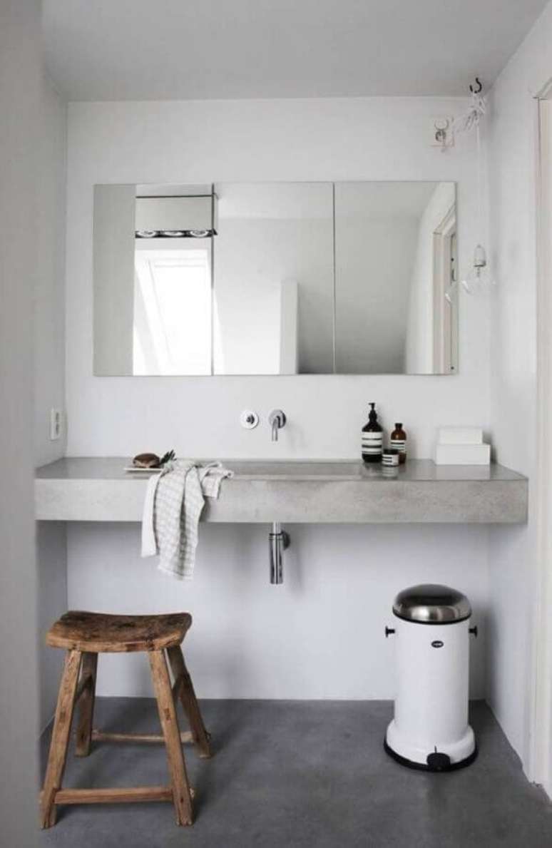 17. Decoração simples para banheiro minimalista branco com bancada de concreto – Foto: Planete-deco