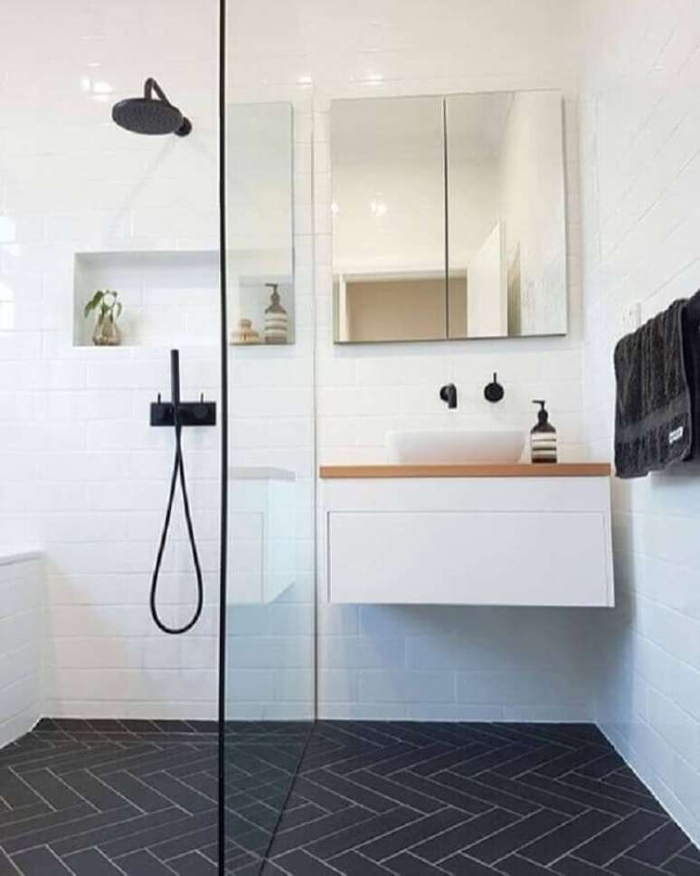 36. Banheiro minimalista branco decorado com metais pretos e gabinete pequeno suspenso – Foto: Archzine