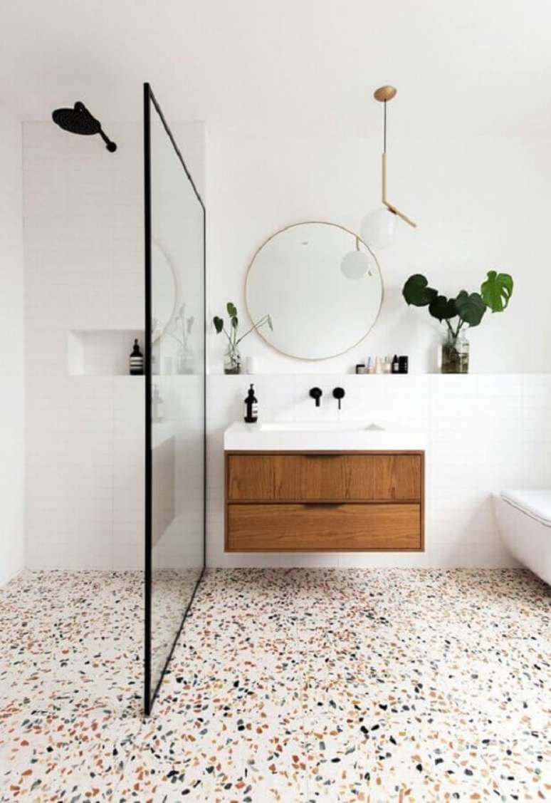 51. Espelho redondo e piso com pontinhos coloridos para decoração de banheiro minimalista – Foto: Jeito de Casa