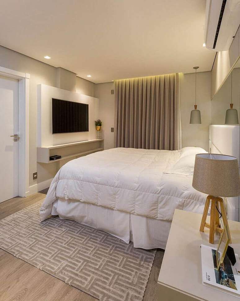 8. Decora&ccedil;&atilde;o de quarto de casal com painel para tv e tapete bege geom&eacute;trico &ndash; Foto: JERA Arquitetura e Engenharia