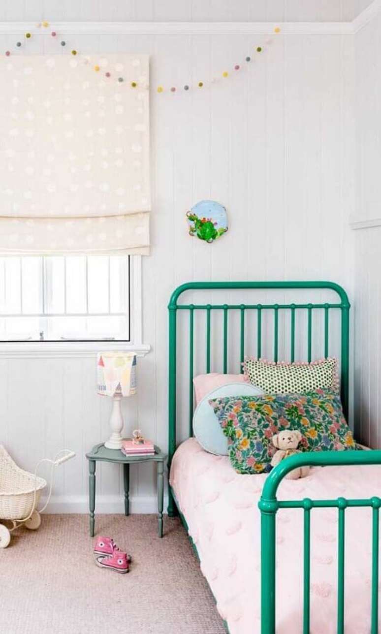 8. Decoração simples com abajur para mesa de cabeceira em quarto de solteiro com cama de ferro verde – Foto: Pinterest
