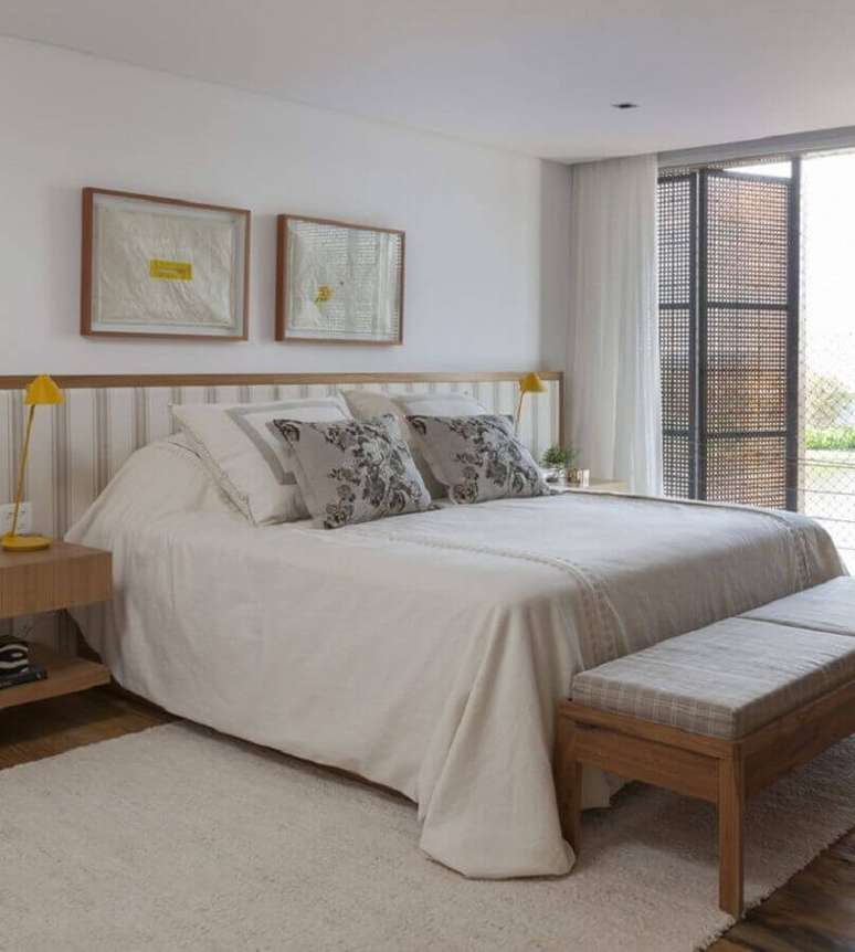 29. Decora&ccedil;&atilde;o de quarto de casal branco com cabeceira listrada e tapete bege claro &ndash; Foto: Mariana Linhares Interiores