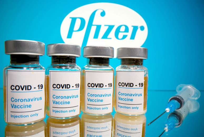 Seringa e frascos rotulados como de vacina para Covid-19 em frente a logo da Pfizer em foto de ilustração
31/10/2020 REUTERS/Dado Ruvic