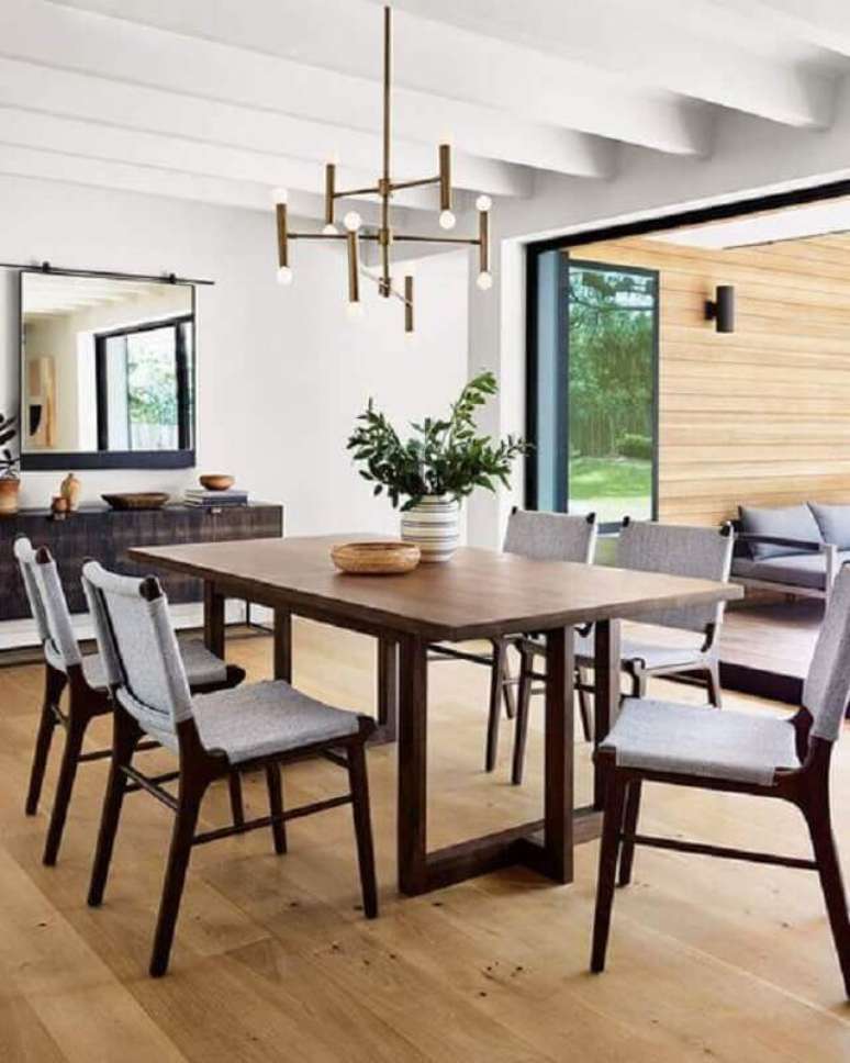 12. Lustre pendente moderno e vaso decorativo para sala de jantar com mesa de madeira – Foto: Horchow