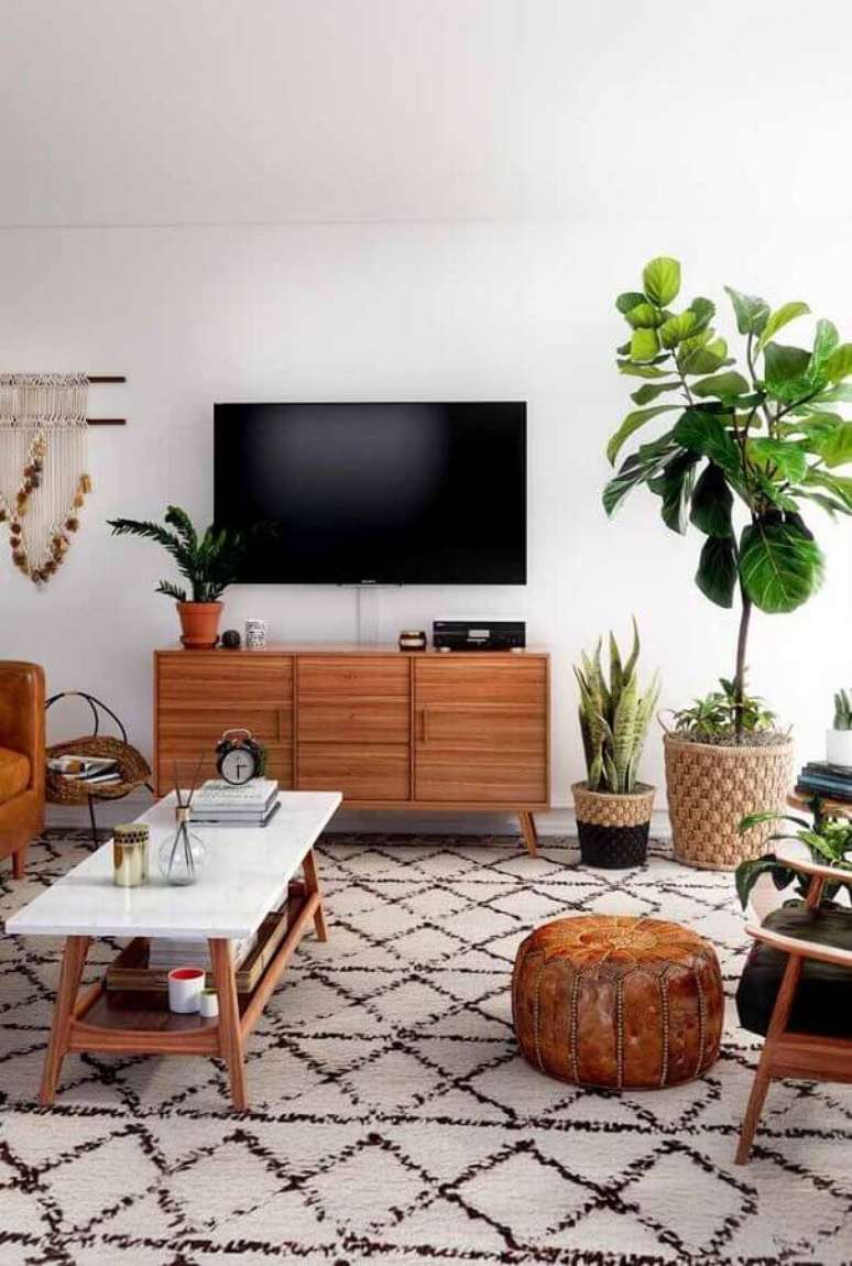 16. Vaso de chão decorativo para sala de TV com puff redondo e poltrona de madeira – Foto: Apartment Therapy