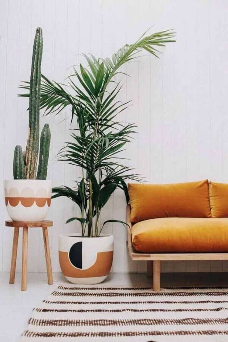 31. Decoração simples com vasos decorativos para sala de estar com sofá de madeira – Foto: Pinterest