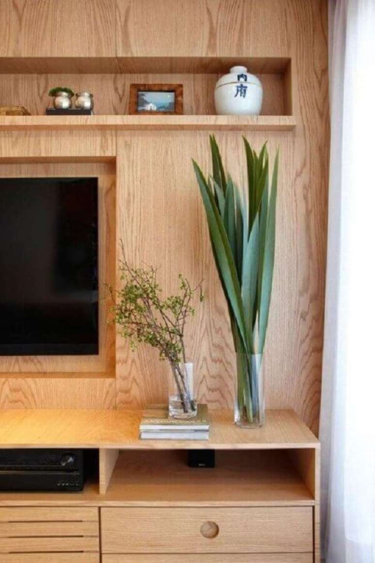 58. Vasos para decorar sala de TV com estante de madeira – Foto: Histórias de Casa