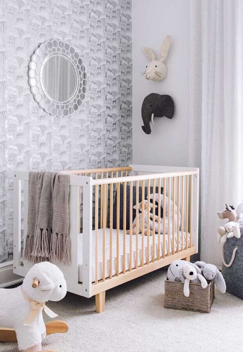 25. Papel de parede tons de cinza para decoração de quarto de bebê com berço de madeira e espelho redondo – Foto: Casa de Valentina