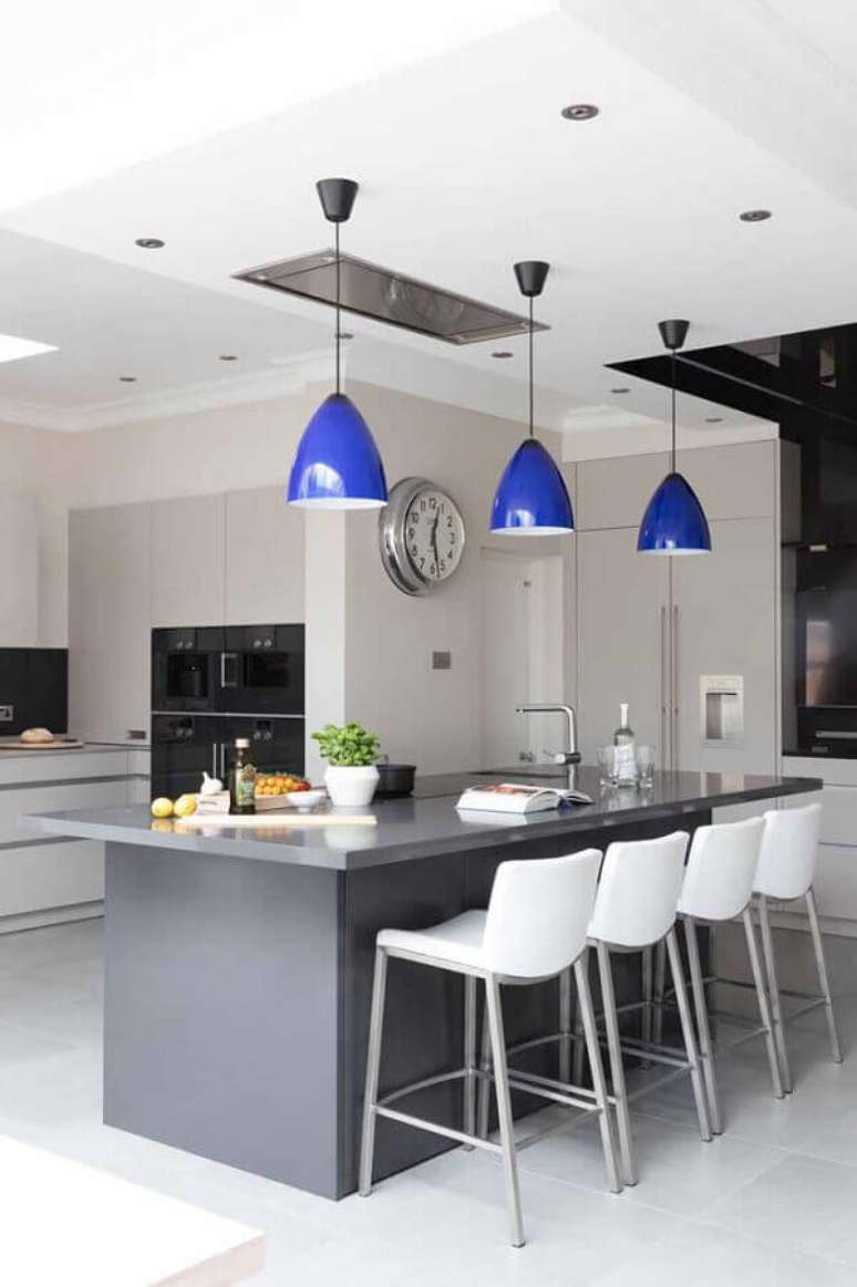 37. Decoração moderna com pendentes azuis para cozinha em tons de cinza com ilha – Foto: Apartment Therapy