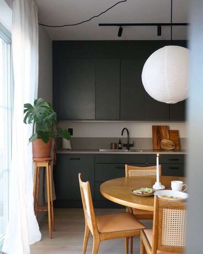 49. Tons de cinza escuro para decoração de cozinha planejada com mesa redonda de madeira – Foto: Futurist Architecture