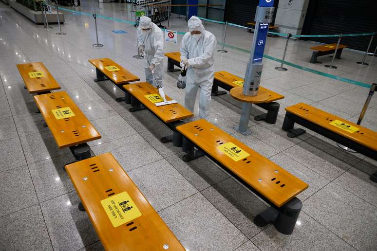 Trabalhadores em trajes de proteção desinfetam área de desembarque do aeroporto de Incheon, na Coreia do Sul
28/12/2020 REUTERS/Kim Hong-Ji