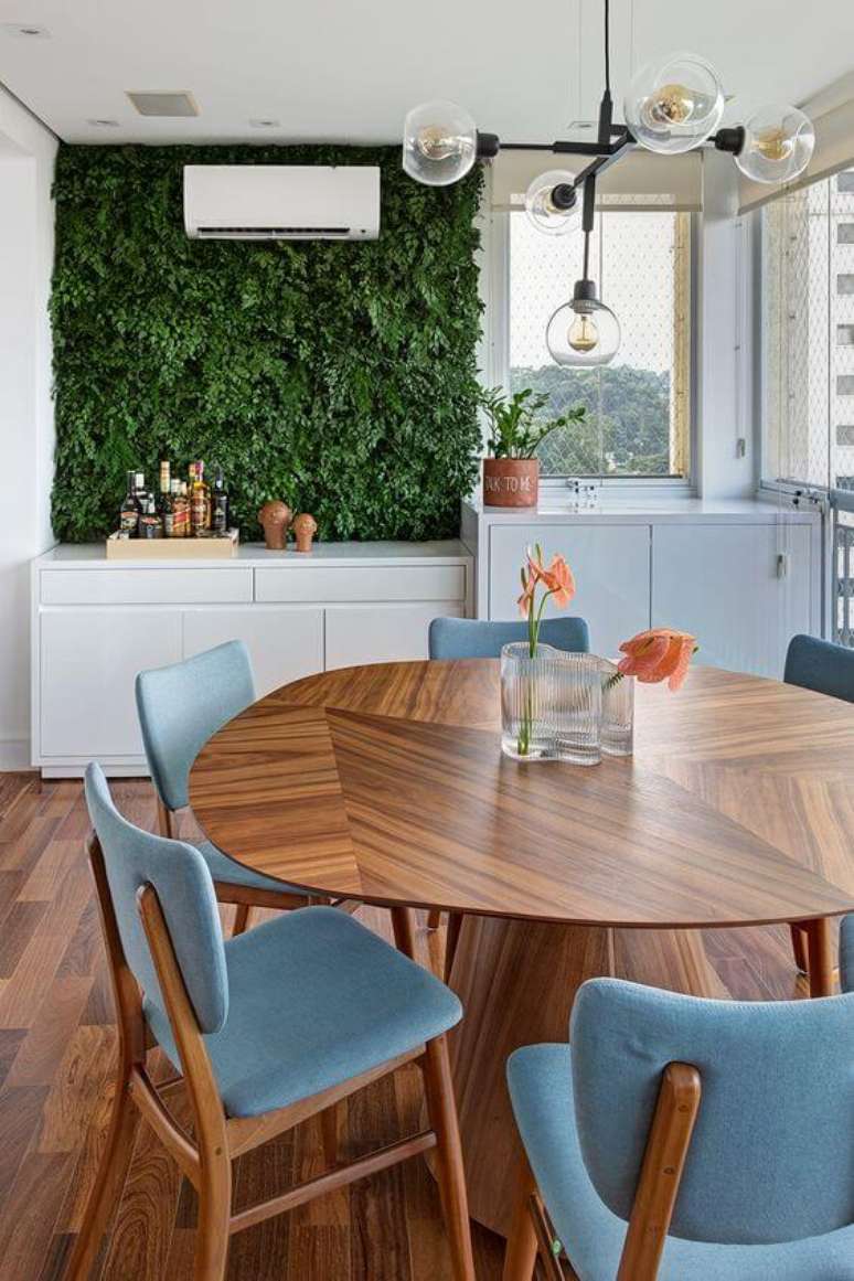 1. Mesa para varanda gourmet com cadeiras azuis e jardim vertical – Via: Apartamento 203