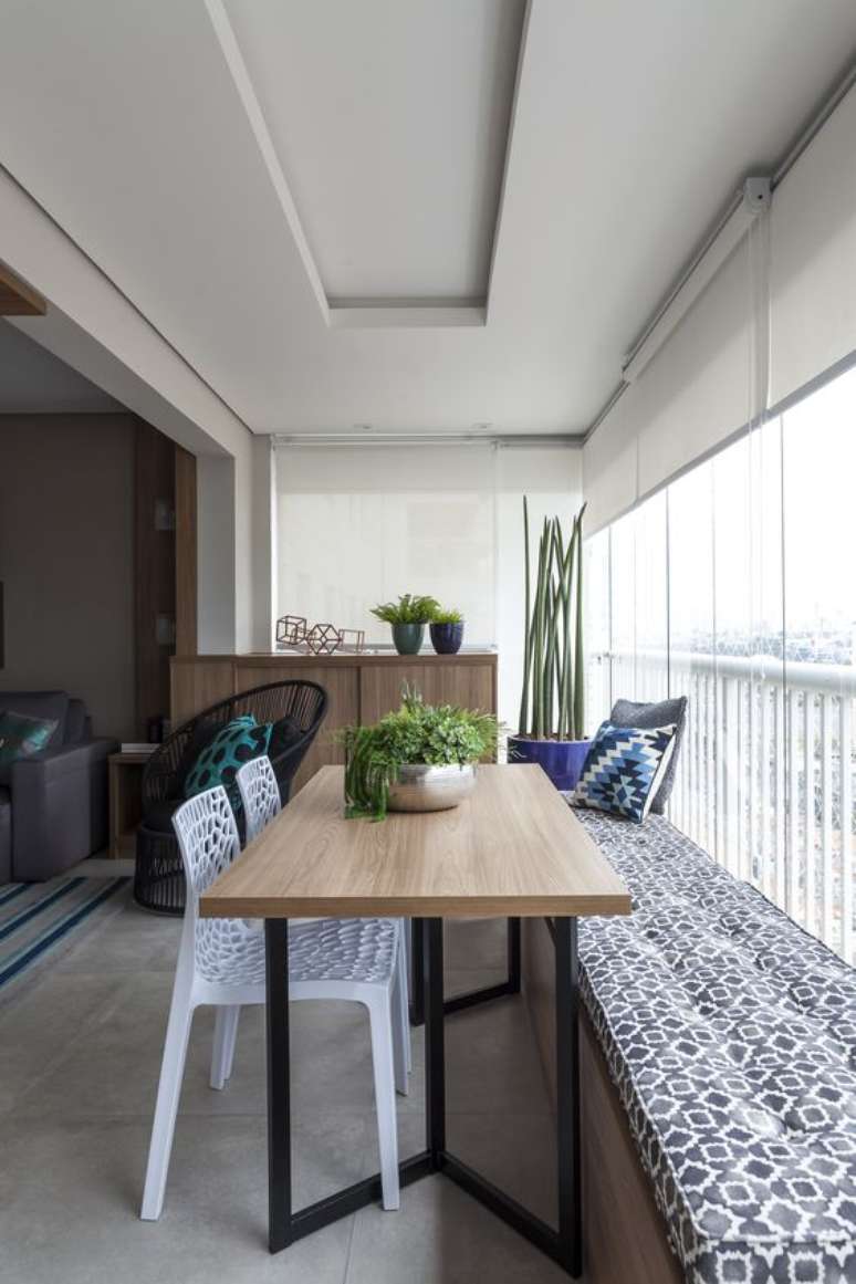 47. Mesa para varanda gourmet de madeira com bancos para ganhar espaço – Via: Rubiam Vieira Interiores