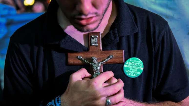 Manifestante contra legalização do aborto segura crucifixo em protesto em frente ao Congresso