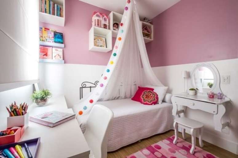 46. Móveis e prateleira para quarto infantil de livros branco se contrastam com a parede rosa. Fonte: SP Estudio