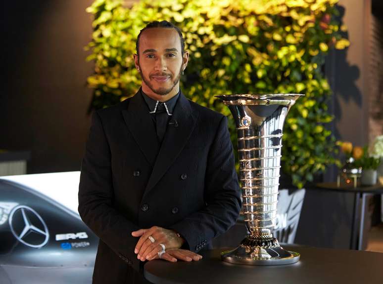 Hamilton com o troféu do Mundial de Construtores, ops, de Pilotos.