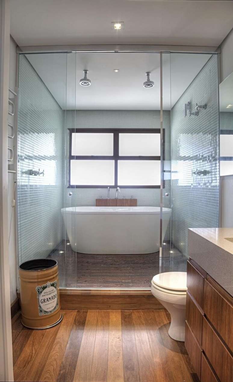 26. Banheiro aconchegante com chuveiro cromado duplo. Projeto por Studio Scatena Arquitetura