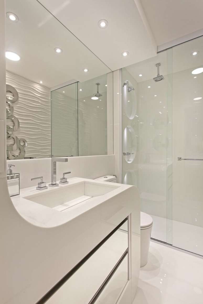 41. Banheiro branco e chuveiro cromado discreto. Projeto por Iara Kilaris