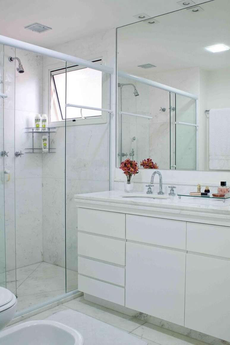 35. Banheiro clean com chuveiro cromado discreto. Projeto por Karen Pisacane